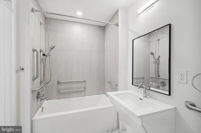 a bathroom with a tub a sink and a mirror