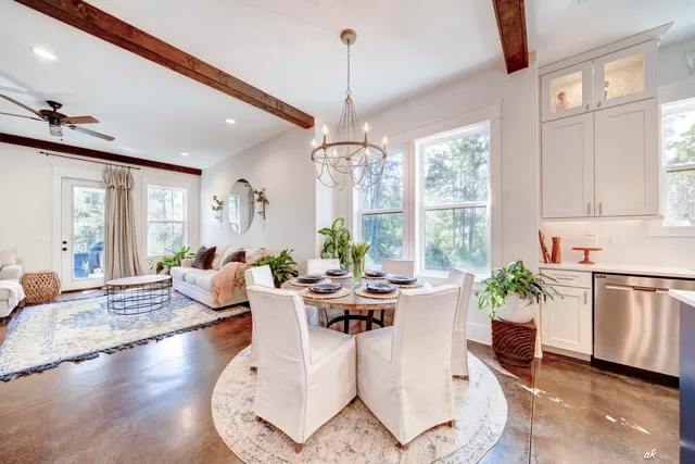 a living room with furniture a large window and plants