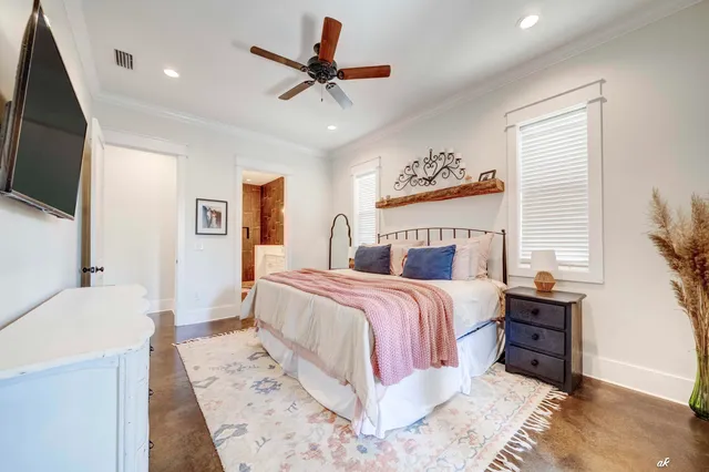 a spacious bedroom with a bed a couch and a flat screen tv