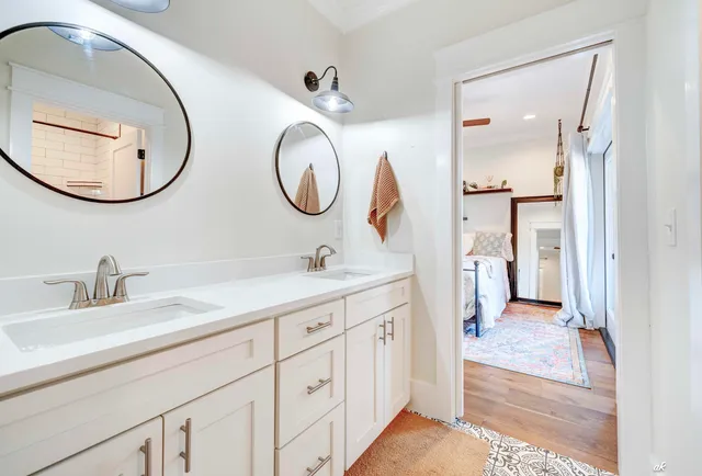 a en suite bathroom with a granite countertop double vanity sink and a mirror