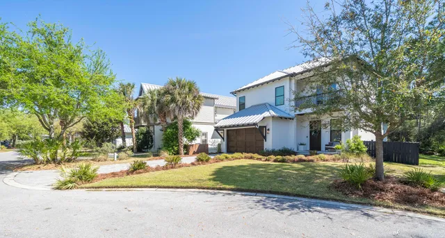 a view of a white house with a yard