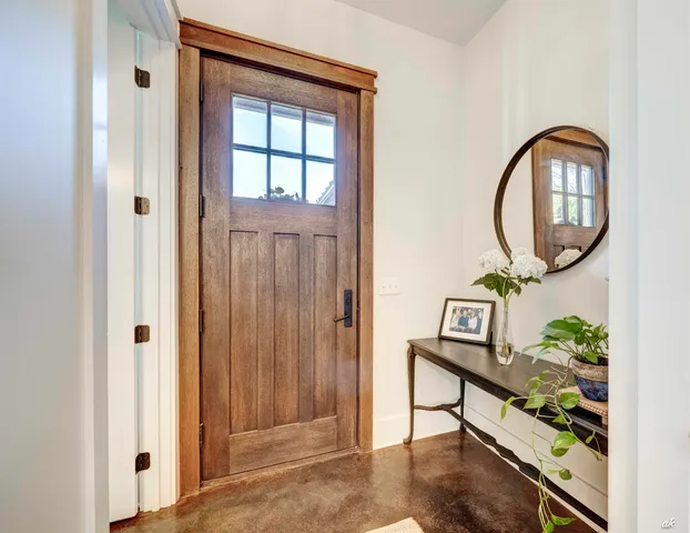an entryway with wooden floor and a potted plant