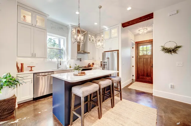 a kitchen with kitchen island granite countertop a sink and a refrigerator