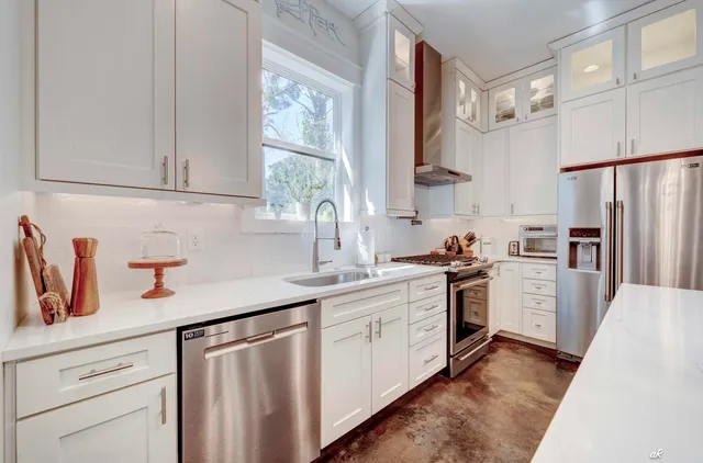 a kitchen with white cabinets and white appliances
