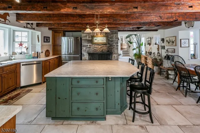 a view of a kitchen with stainless steel appliances granite countertop a table and chairs in it