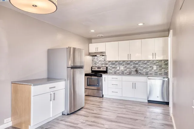 a kitchen with white cabinets and stainless steel appliances