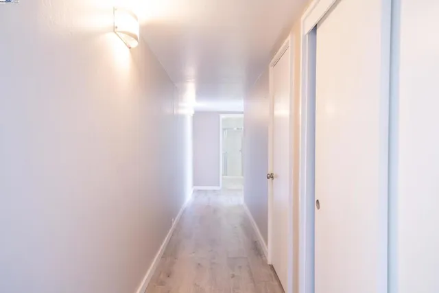 a view of a hallway with wooden floor