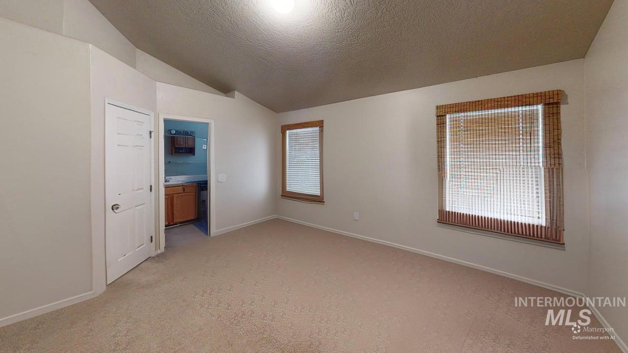 16609 Old Friendship Way Caldwell, ID 83607 - Photo 12 of 23 Vaulted ceiling, recessed lighting, neutral carpet, light-toned walls, and a window with blinds