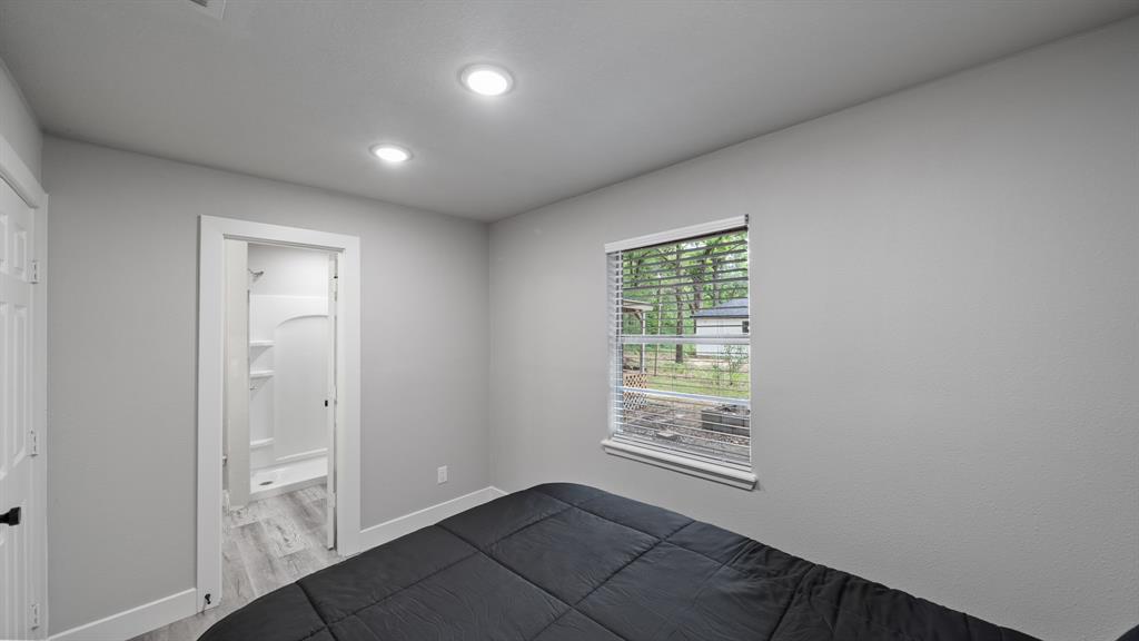 129 King Arthur Road Mabank, TX 75156 - Photo 17 of 33 Bedroom with recessed lighting, light gray walls, and a window with blinds overlooking greenery
