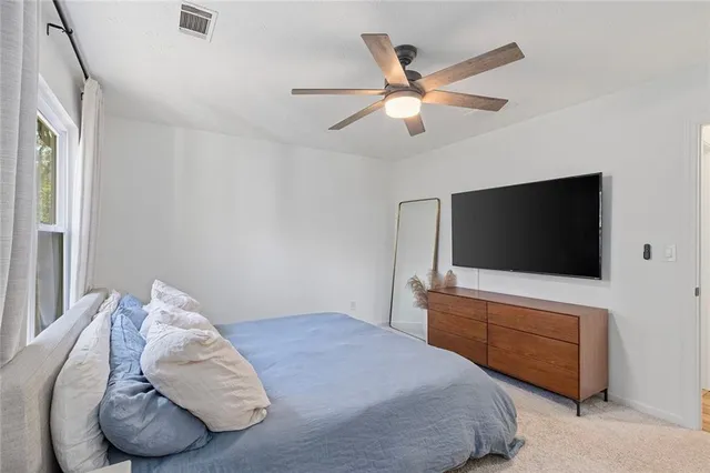 a spacious bedroom with a large bed and a chandelier