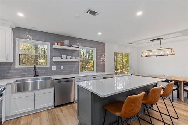 a kitchen with a table chairs sink and cabinets