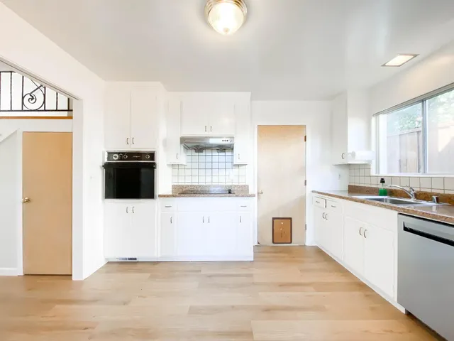 a kitchen with stainless steel appliances a refrigerator sink and white cabinets