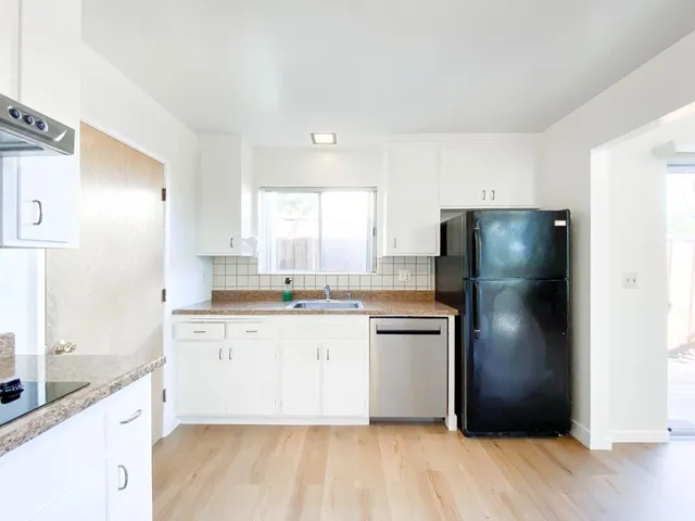 a kitchen with stainless steel appliances granite countertop a refrigerator a sink a stove and oven