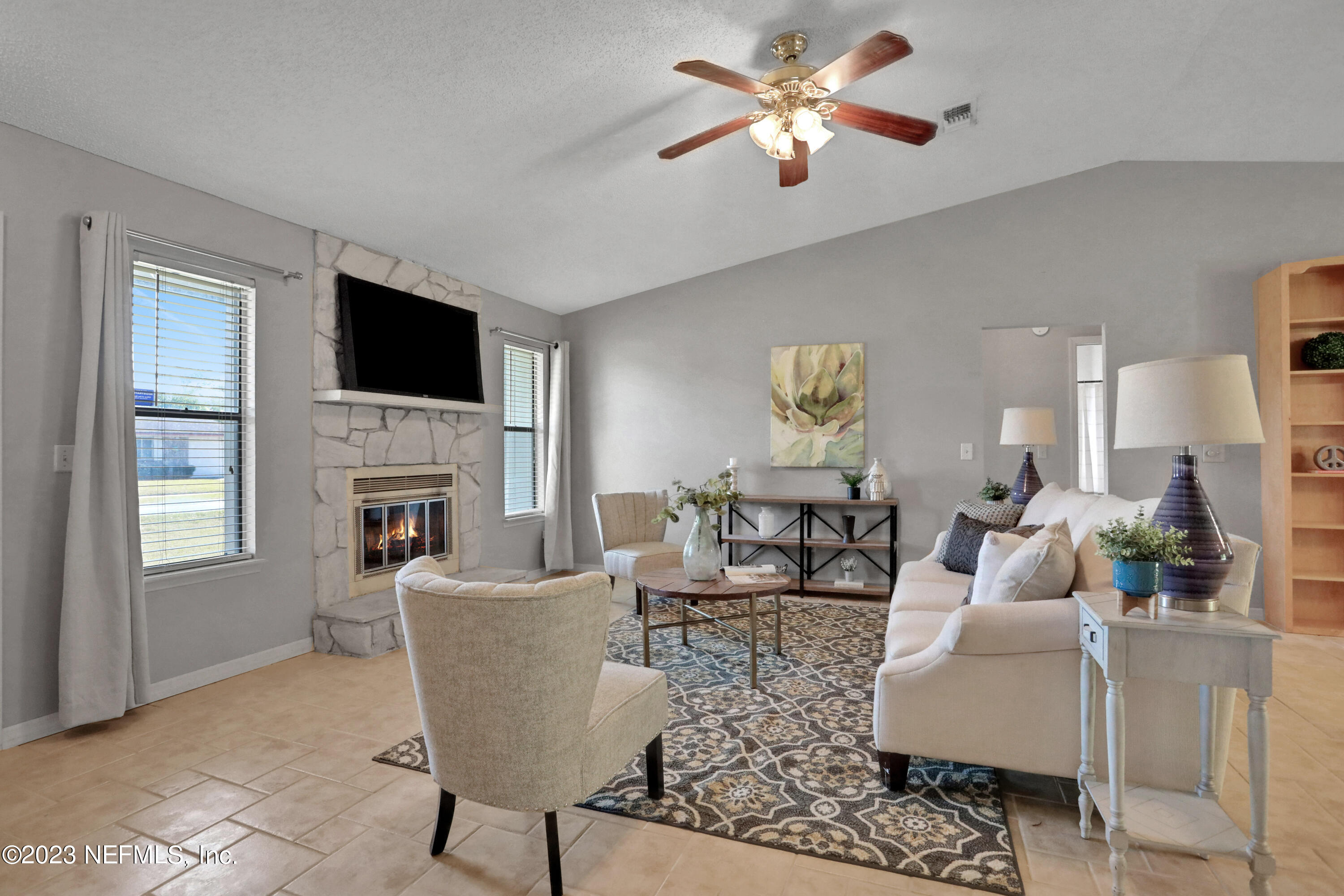 3826 Eunice Road Jacksonville, FL 32250 - Photo 26 of 45 a living room with furniture a fireplace and a flat screen tv