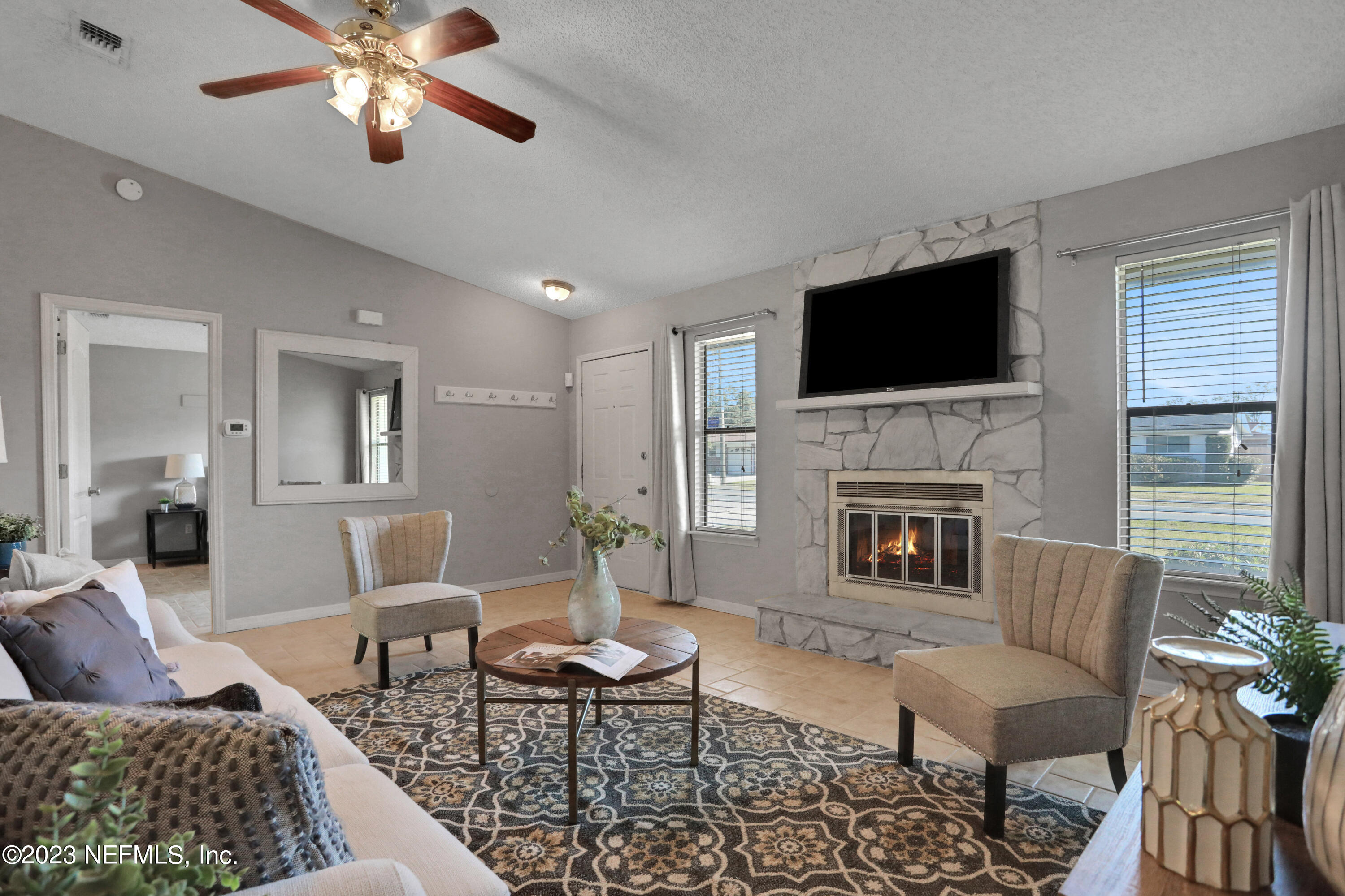 3826 Eunice Road Jacksonville, FL 32250 - Photo 29 of 45 a living room with furniture a flat screen tv and a fireplace