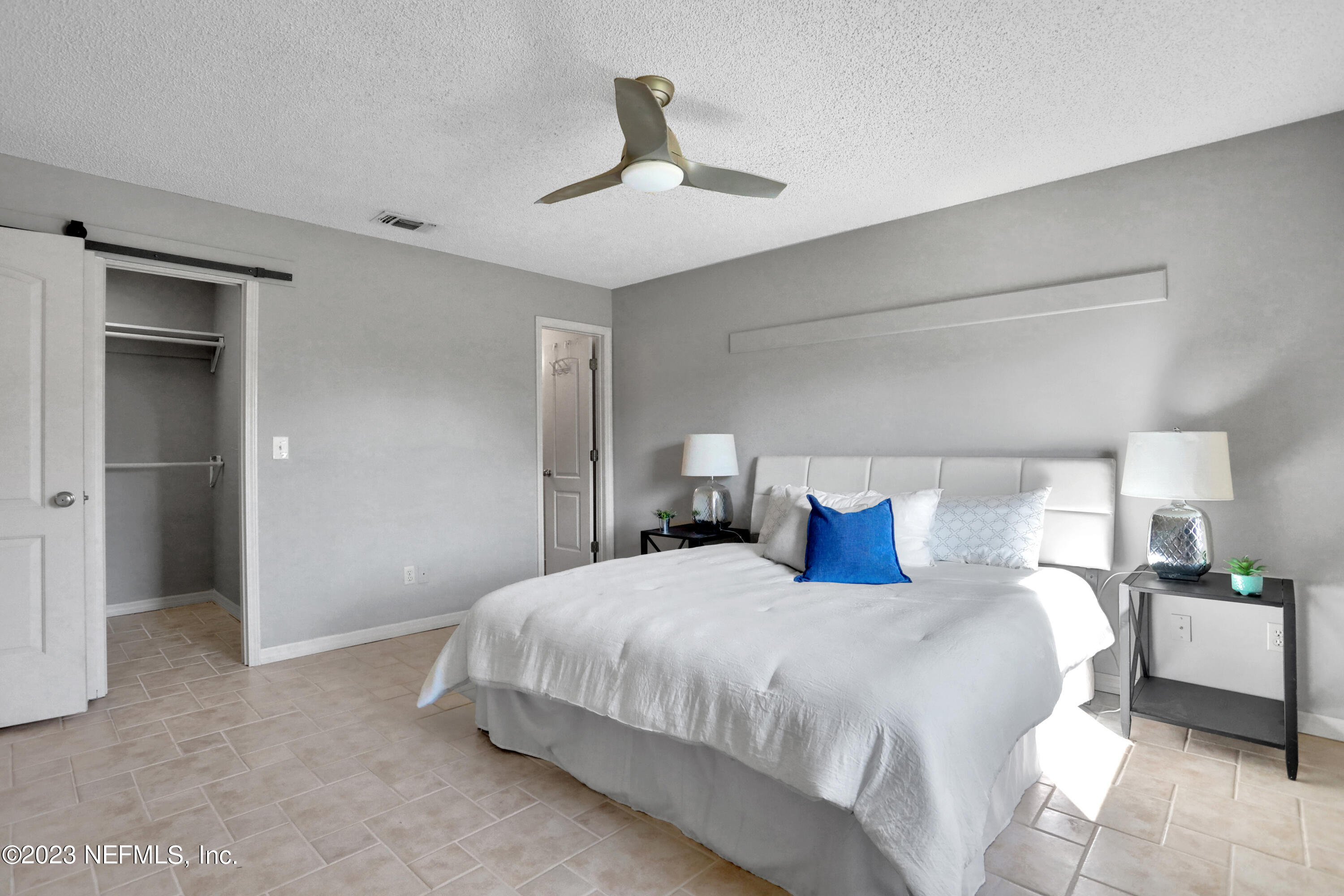 3826 Eunice Road Jacksonville, FL 32250 - Photo 3 of 45 a bedroom with a bed and a lamp