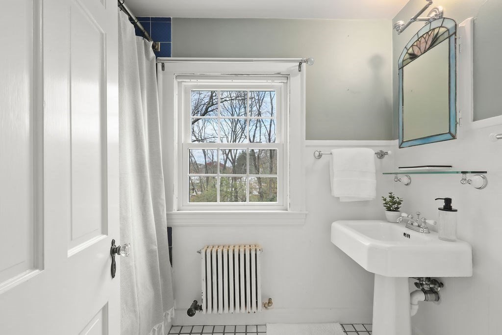 1297 Old Worcester Road Framingham, MA 01701 - Photo 26 of 41 a bathroom with a sink a mirror and a window