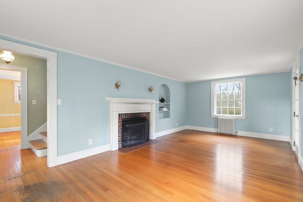 1297 Old Worcester Road Framingham, MA 01701 - Photo 7 of 41 a view of empty room with wooden floor and fireplace