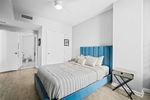 a bedroom with a bed and wooden floor