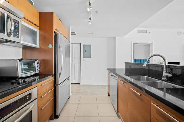 a kitchen with stainless steel appliances granite countertop a sink and a refrigerator