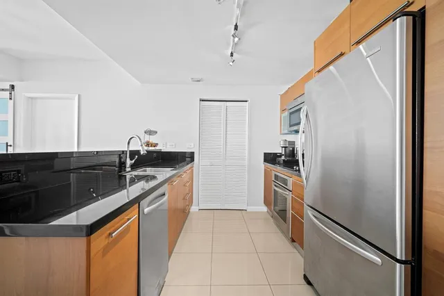 a large kitchen with a sink and stainless steel appliances