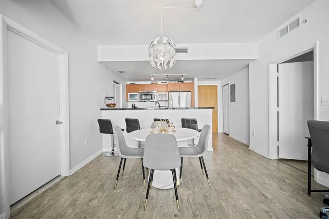 a view of a dining room with furniture a chandelier and wooden floor