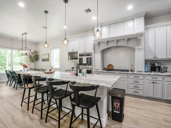 a kitchen with kitchen island a stove a table and chairs in it