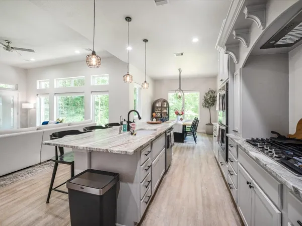 a large kitchen with a large stove top oven and stainless steel appliances