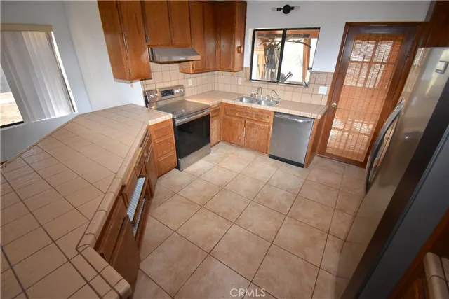 a kitchen with stainless steel appliances granite countertop a sink and a stove top oven