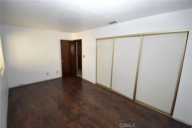 an empty room with wooden floor and closet