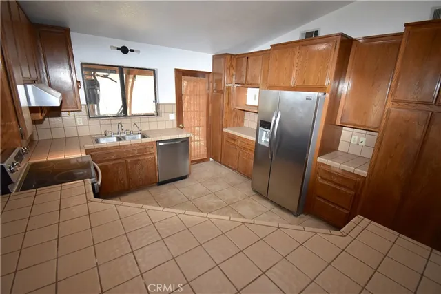 a kitchen with stainless steel appliances a refrigerator and a sink