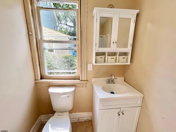 a bathroom with a sink and mirror with toilet