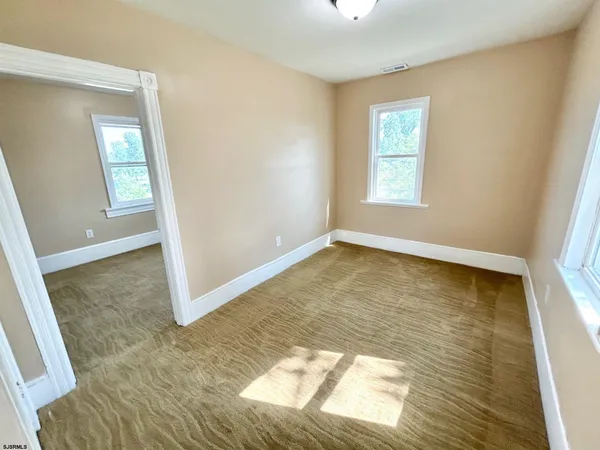 a view of a room with wooden floor and window