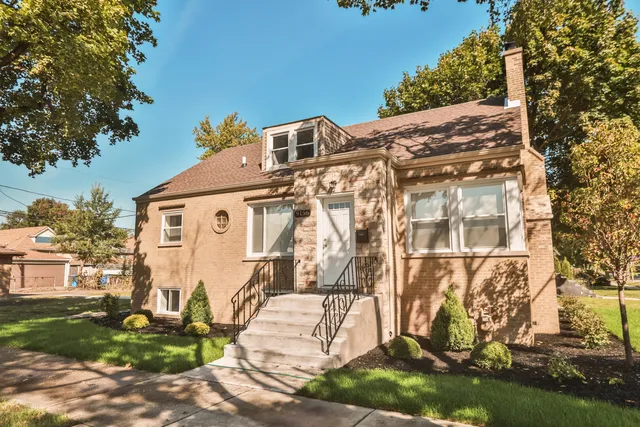 a view of a white house with a yard and plants