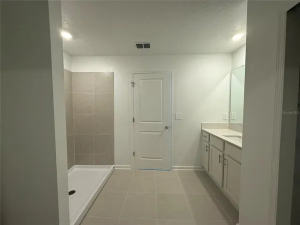 a bathroom with a granite countertop sink toilet a mirror and shower