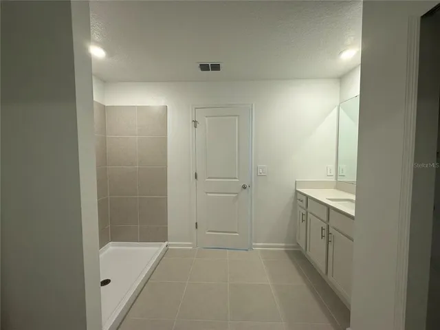 a bathroom with a granite countertop sink toilet a mirror and shower