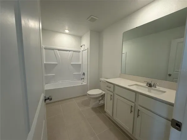 a white toilet sitting next to a shower