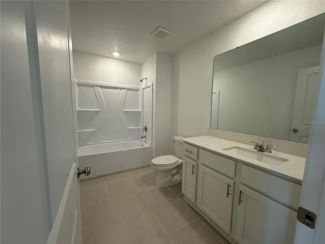 a white toilet sitting next to a shower