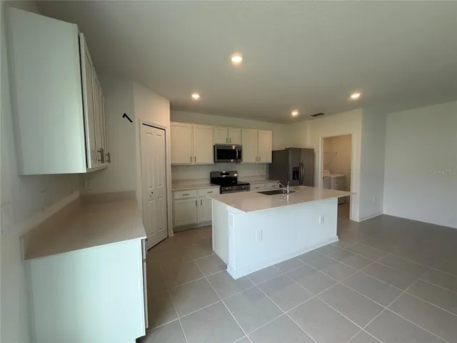 a large kitchen with stainless steel appliances lots of counter top space