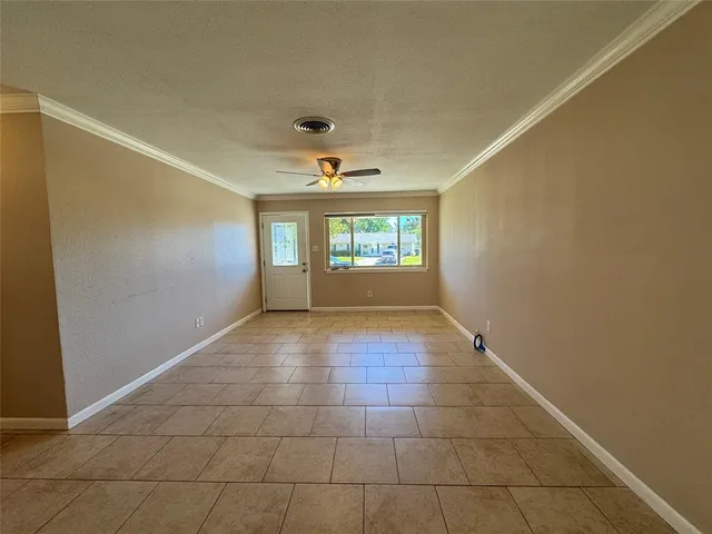 an empty room with windows and cabinet