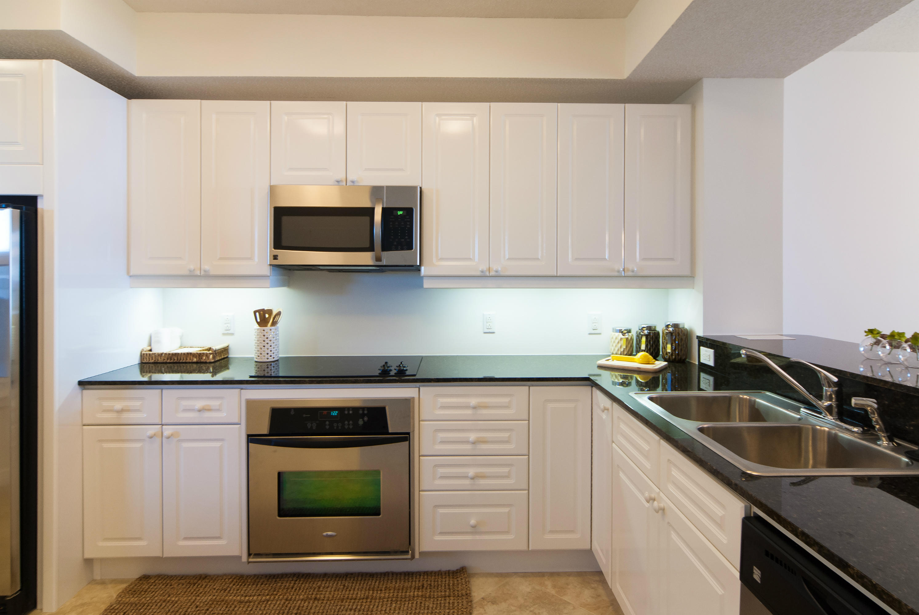 8501 Gulf Boulevard, Unit 1E Navarre, FL 32566 - Photo 6 of 12 a kitchen with granite countertop a sink a stove and microwave