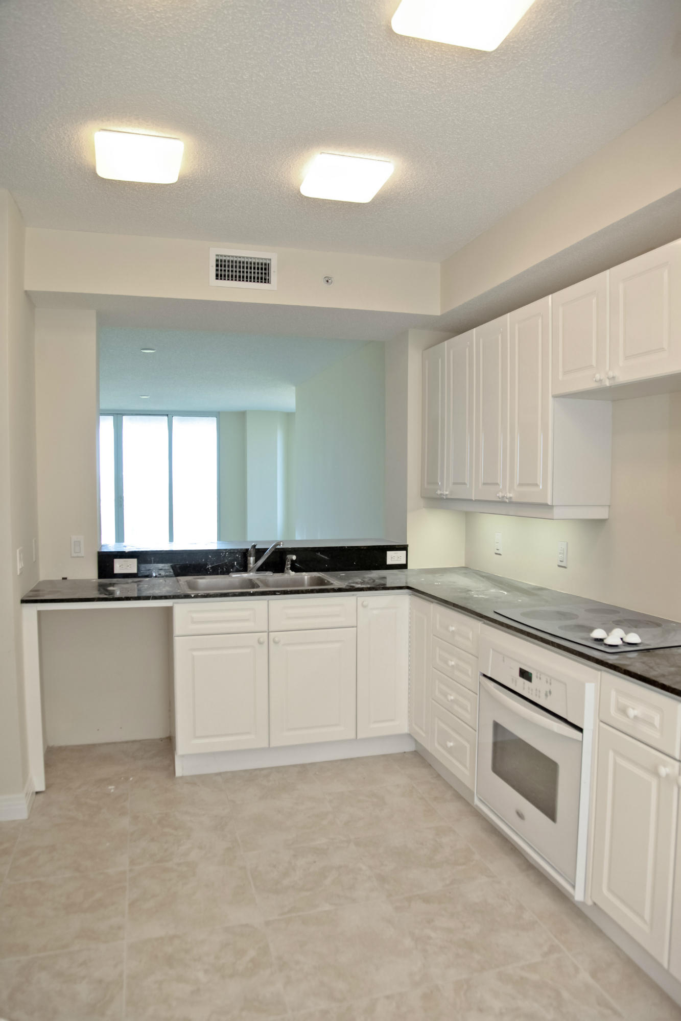 8501 Gulf Boulevard, Unit 1E Navarre, FL 32566 - Photo 9 of 12 a kitchen with granite countertop white cabinets and white appliances