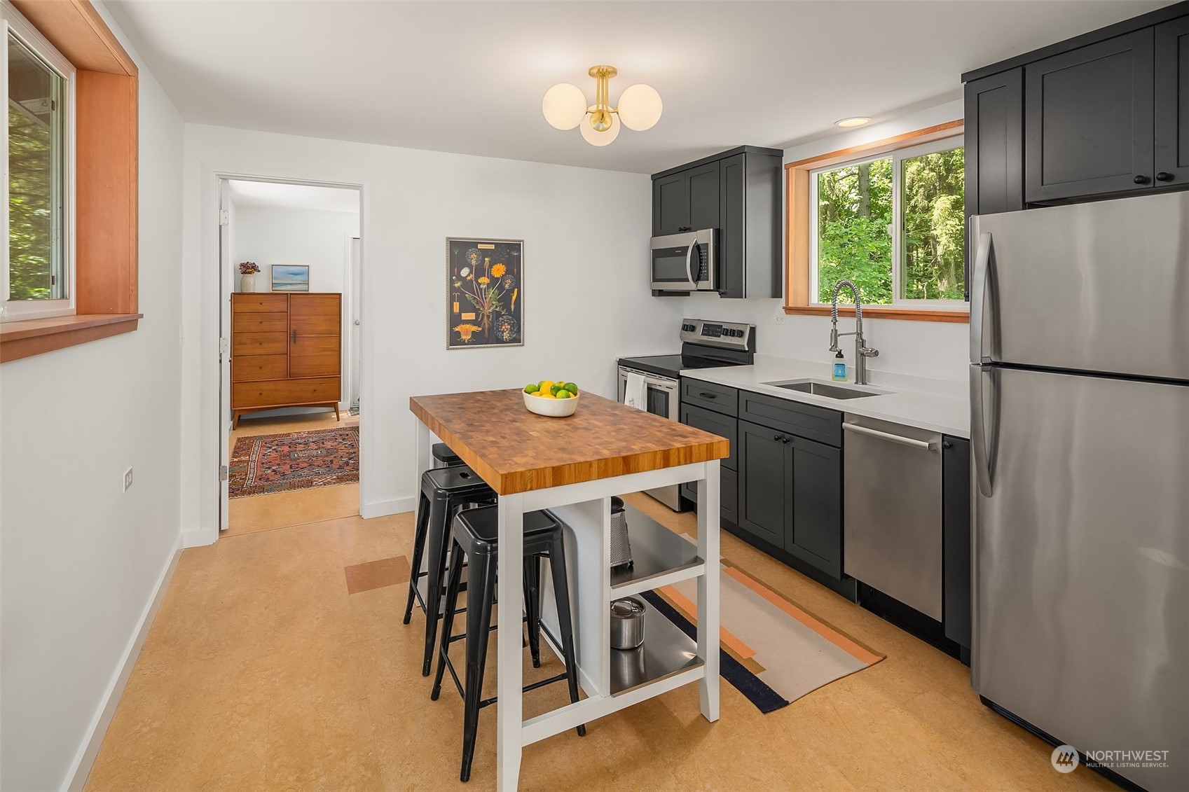 12150 Southwest Shawnee Road Vashon, WA 98070 - Photo 10 of 25 a kitchen with a table chairs refrigerator and cabinets