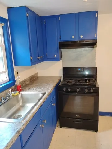 a kitchen with wooden cabinets and a stove top oven