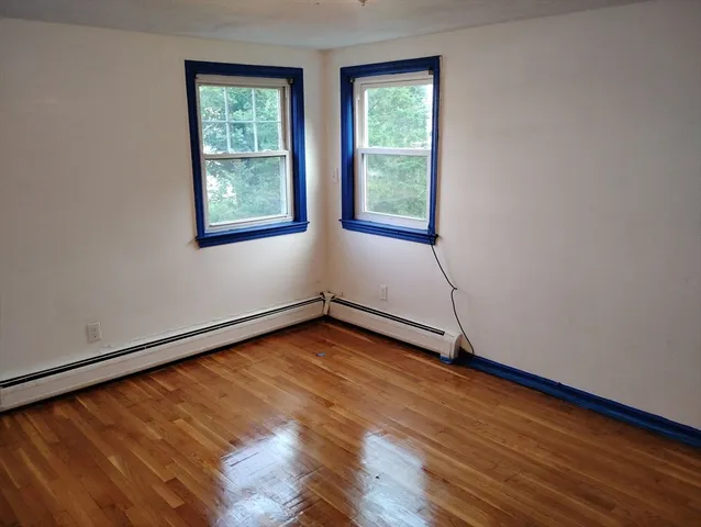a view of a room with wooden floor and a window