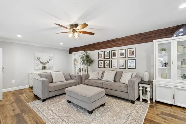 a living room with furniture flat screen tv and wooden floor