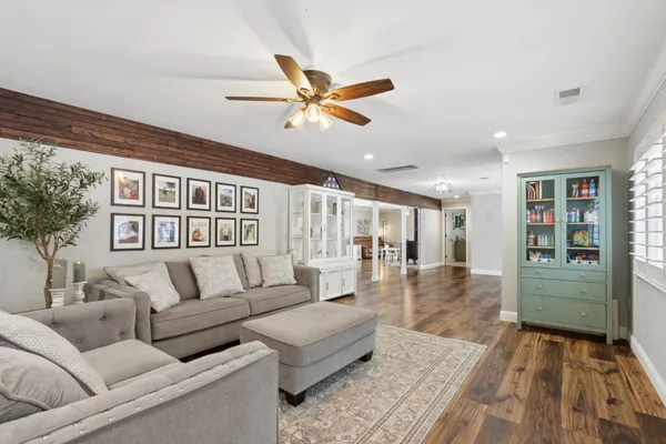 a living room with furniture and a wooden floor