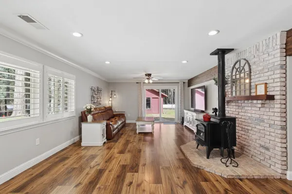 a view of a dining room and livingroom with furniture wooden floor a rug and a chandelier