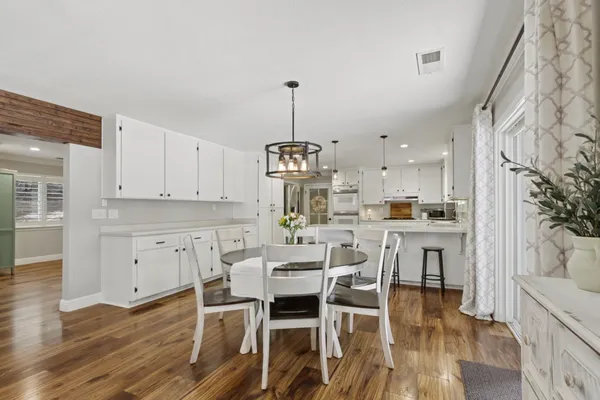 a kitchen with cabinets stainless steel appliances and wooden floor