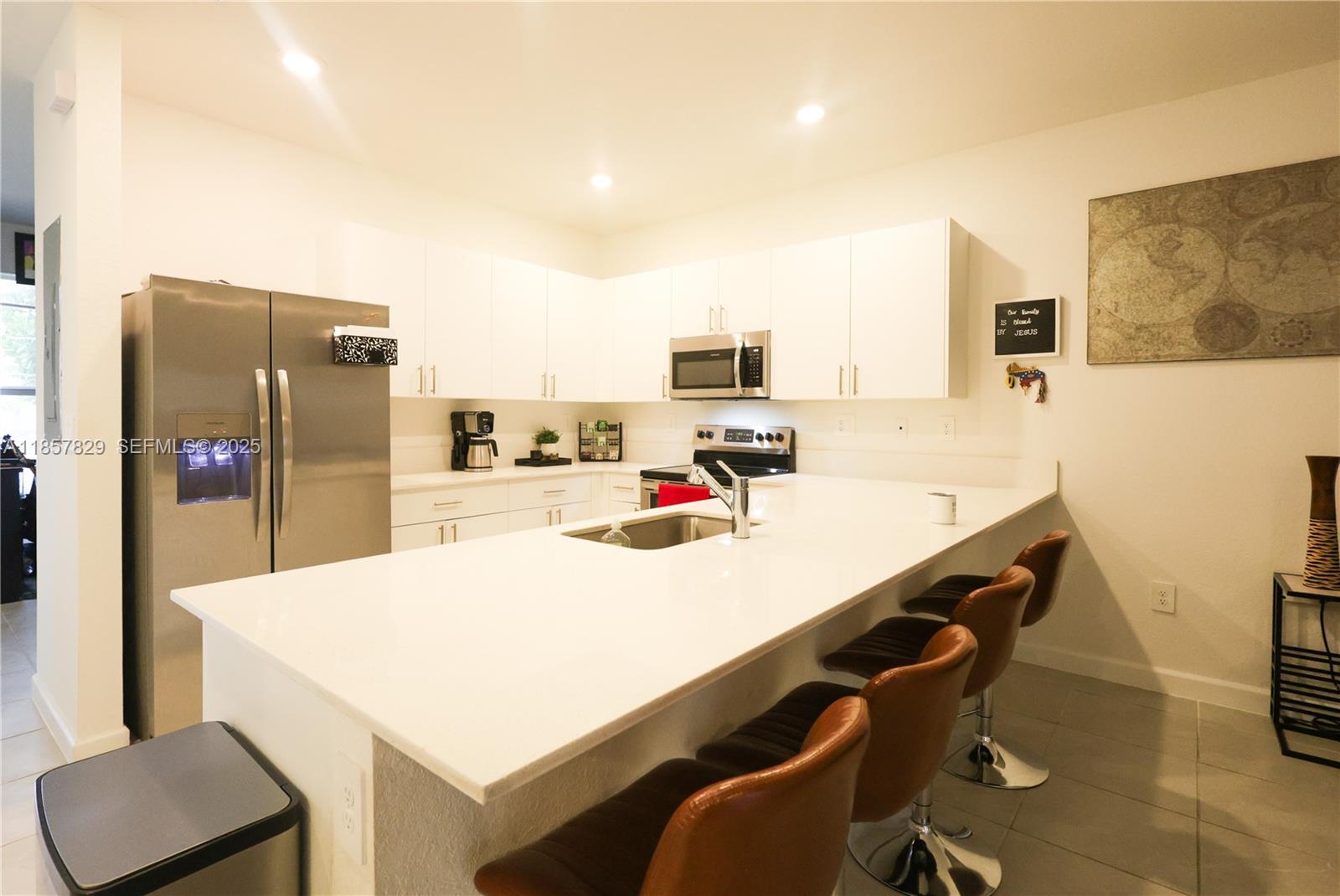 14824 Southwest 265th Street Homestead, FL 33032 - Photo 4 of 17 a kitchen with kitchen island a refrigerator stove and a sink